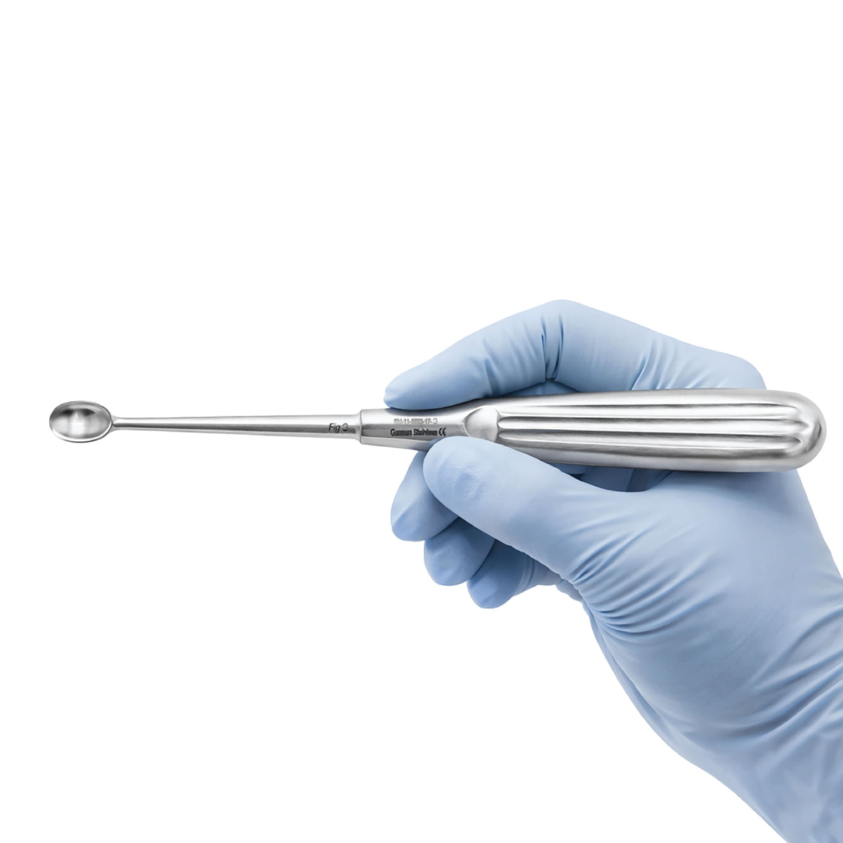 A stainless steel dental instrument with a long, slender shaft and a spoon-like tip, held by a hand wearing a light blue nitrile glove against a plain white background.