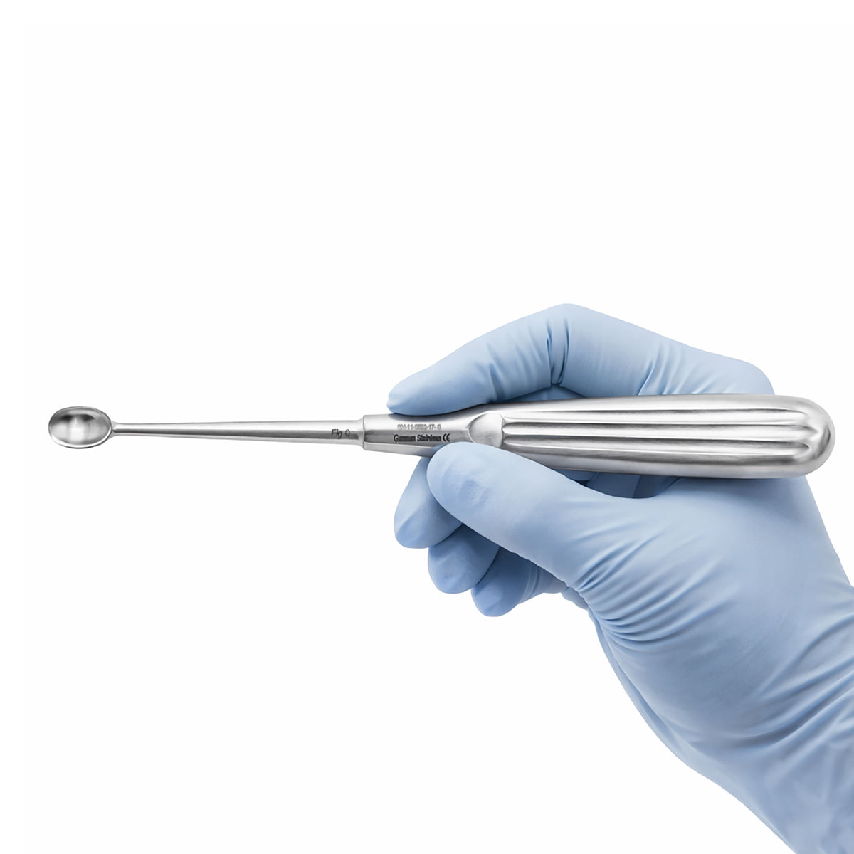 A stainless steel dental instrument with a long, slender shaft and a spoon-like tip, held by a hand wearing a light blue nitrile glove against a plain white background.