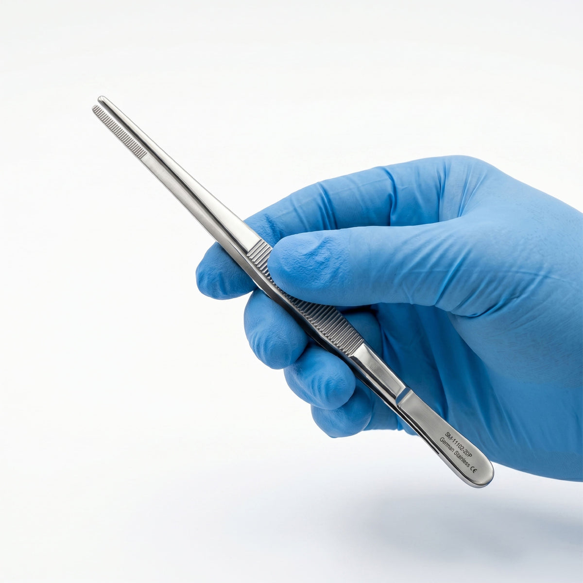 Hand wearing a blue glove holding a metallic tool on a white background