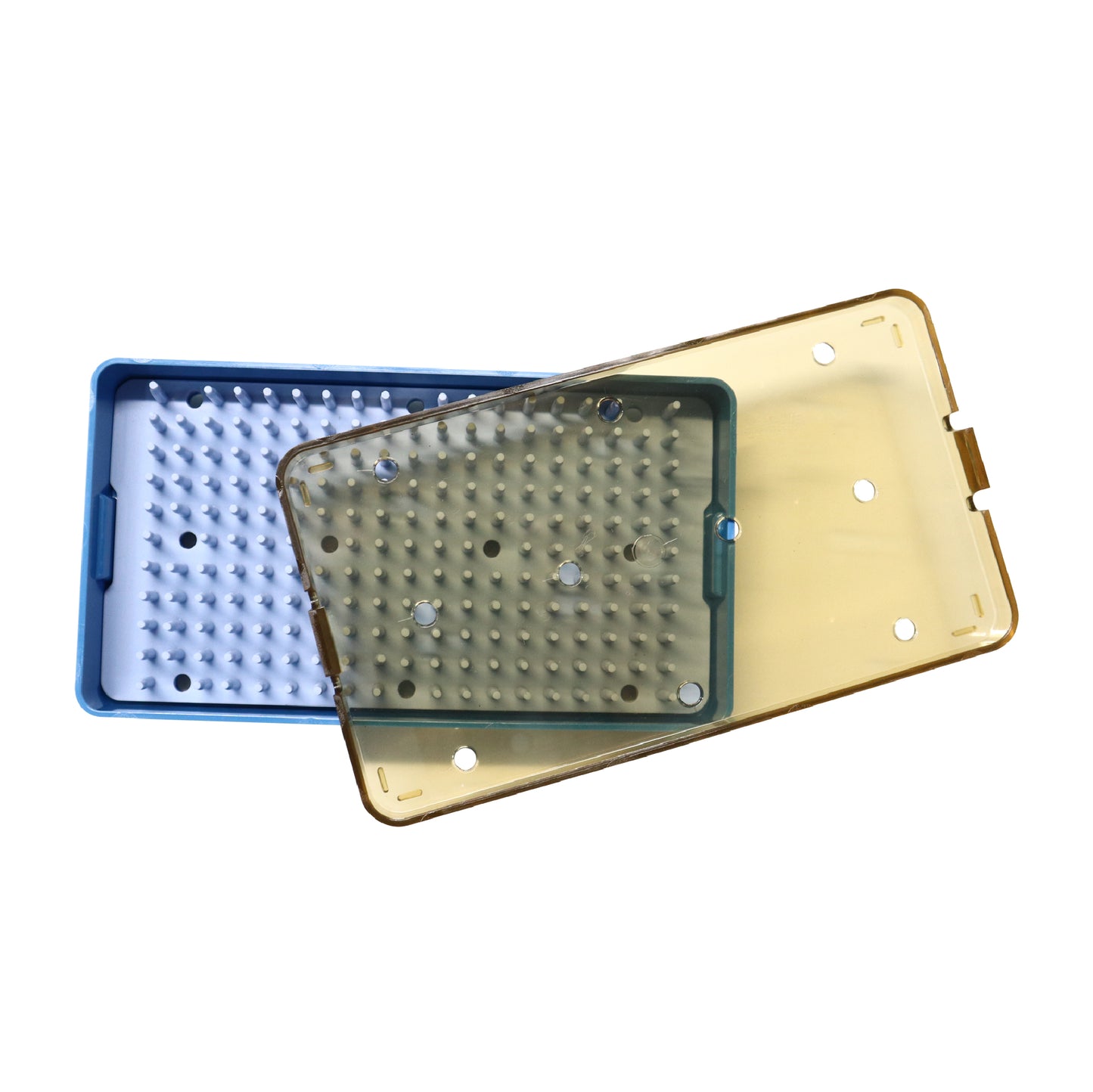 Two plastic medical sterilization trays, one blue and one green, each containing a white silicone finger mat and covered with a transparent yellow-tinted perforated lid.