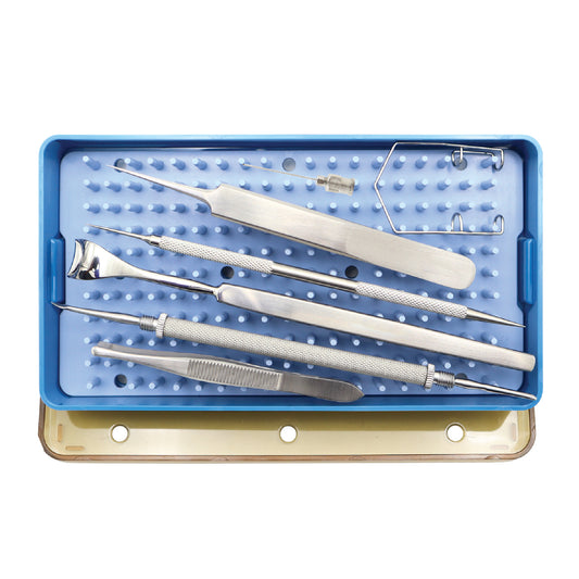 A collection of stainless steel ophthalmic surgical instruments, including a lid retractor, speculum, and forceps, arranged in a blue autoclavable sterilization tray with a silicone pin mat.