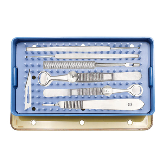 An open sterilized surgical tray containing various cataract and chalazion surgical instruments made of stainless steel and metal, neatly arranged on padded slots.